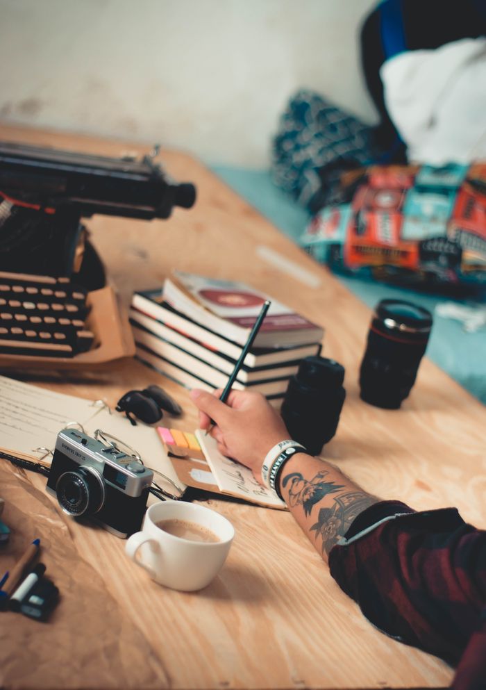 A cozy workspace featuring a typewriter, camera, and coffee cup for a creative writing session.