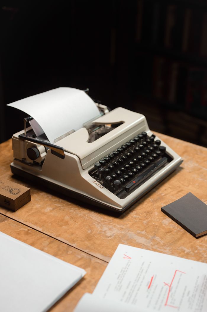 services-02 Classic typewriter on a wooden table with papers, evoking nostalgia.